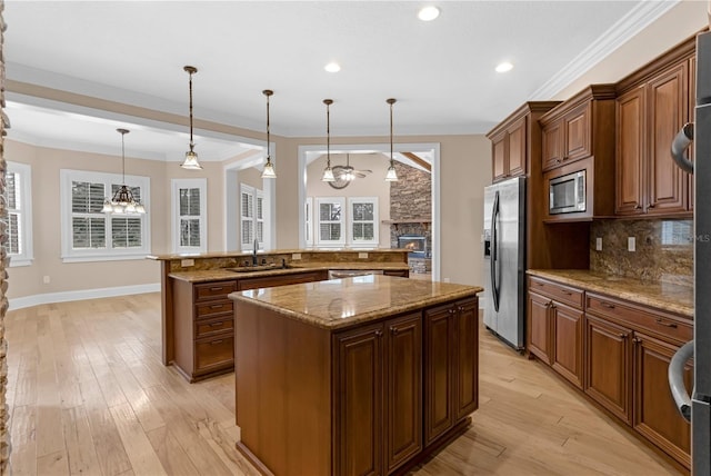 1325 Otters View Ct, Fruitland Park, FL 34731 - kitchen featuring a kitchen island, appliances with stainless steel finishes, a stone fireplace, a chandelier, and backsplash