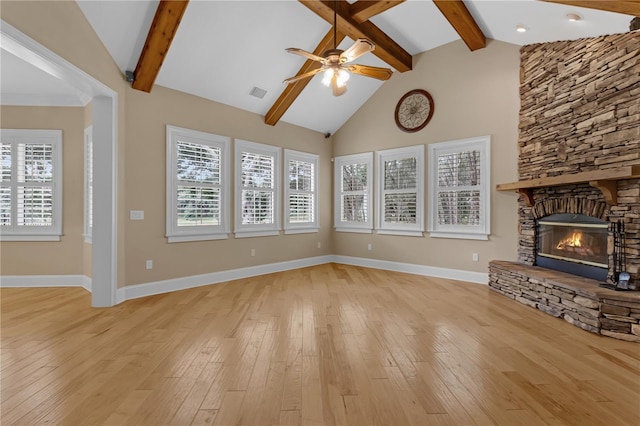 1325 Otters View Ct, Fruitland Park, FL 34731 - unfurnished living room with a ceiling fan, a stone fireplace, beamed ceiling, light wood-type flooring, and healthy amount of natural light