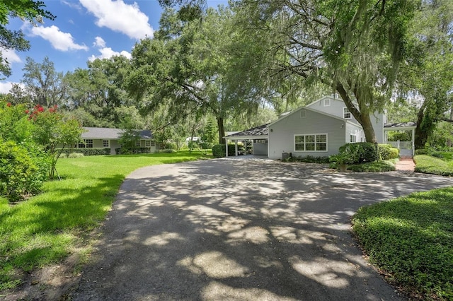 9223 Silver Lake Dr, Leesburg, FL 34788 - view of side of home with asphalt driveway, a yard, and an attached carport