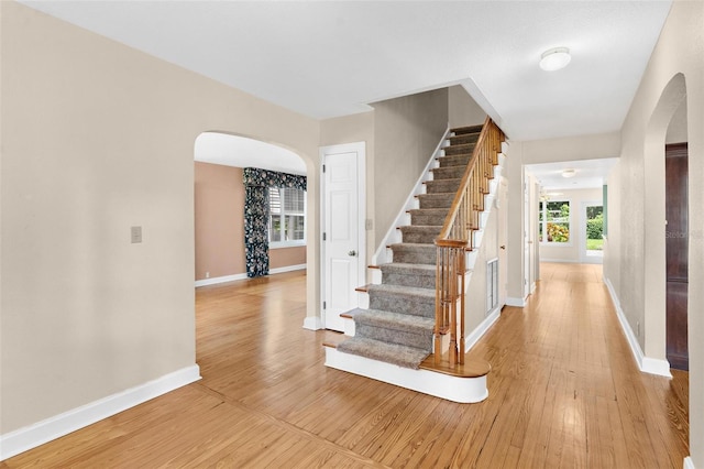 9223 Silver Lake Dr, Leesburg, FL 34788 - staircase featuring arched walkways and hardwood / wood-style flooring