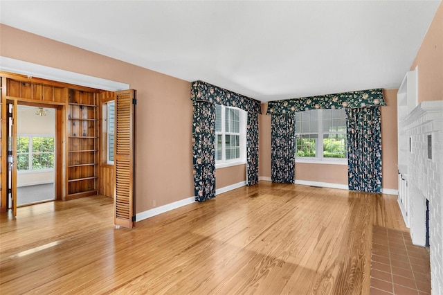 9223 Silver Lake Dr, Leesburg, FL 34788 - unfurnished living room with wood finished floors, plenty of natural light, and a fireplace