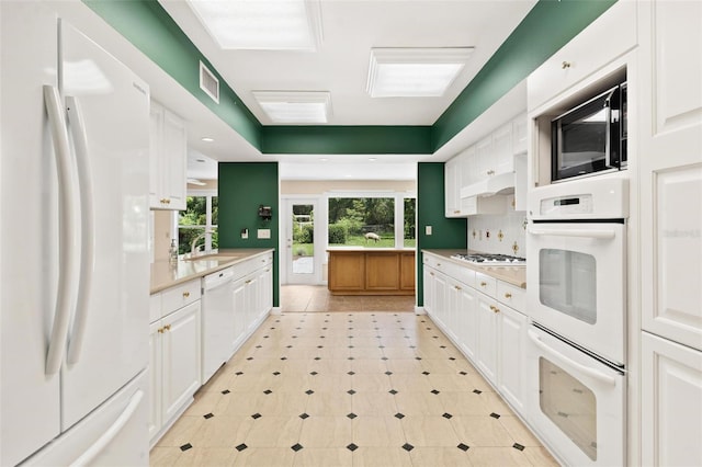 9223 Silver Lake Dr, Leesburg, FL 34788 - kitchen with white appliances, white cabinetry, and light countertops