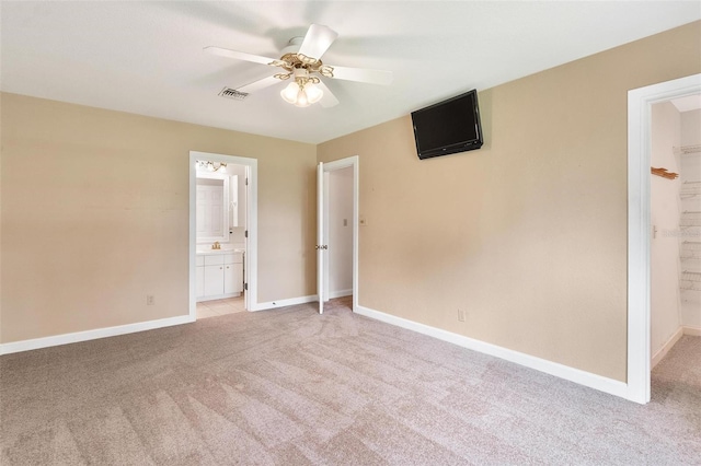 9223 Silver Lake Dr, Leesburg, FL 34788 - unfurnished bedroom featuring light carpet, ensuite bathroom, a ceiling fan, and a spacious closet