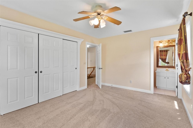 9223 Silver Lake Dr, Leesburg, FL 34788 - unfurnished bedroom with light colored carpet, a closet, ensuite bath, and a ceiling fan