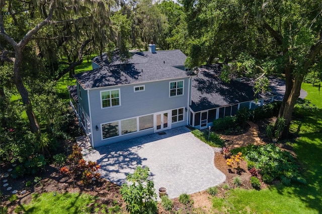 9223 Silver Lake Dr, Leesburg, FL 34788 - back of house featuring a patio area, a chimney, and roof with shingles