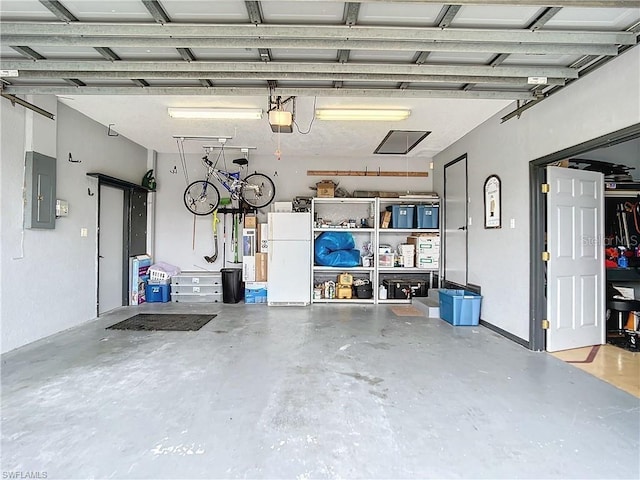 3723 Toulouse Ct, Punta Gorda, FL 33950 - garage featuring freestanding refrigerator, electric panel, and a garage door opener