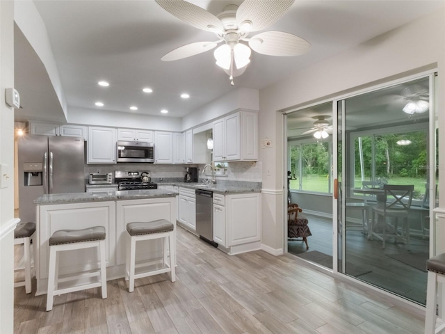 5556 Round Lake Rd, Apopka, FL 32712 - kitchen featuring appliances with stainless steel finishes, a ceiling fan, light wood-style floors, white cabinets, and recessed lighting