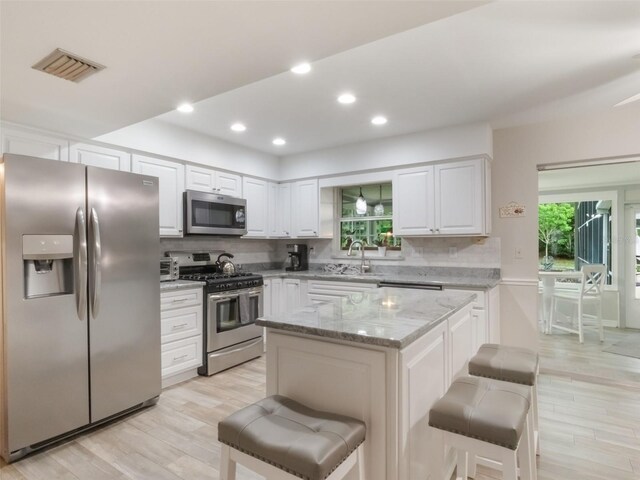 5556 Round Lake Rd, Apopka, FL 32712 - kitchen featuring stainless steel appliances, light wood-type flooring, light stone countertops, decorative backsplash, and recessed lighting