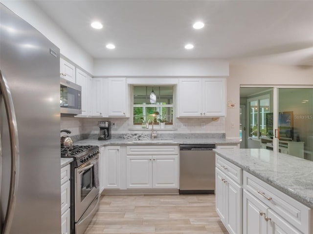 5556 Round Lake Rd, Apopka, FL 32712 - kitchen with appliances with stainless steel finishes, white cabinets, light wood-style floors, and recessed lighting