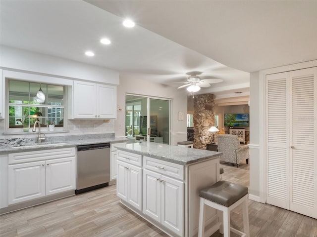 5556 Round Lake Rd, Apopka, FL 32712 - kitchen with dishwasher, light wood-style flooring, a kitchen island, recessed lighting, and white cabinetry