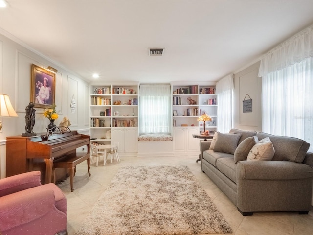 5556 Round Lake Rd, Apopka, FL 32712 - living room with light tile patterned floors, built in shelves, and ornamental molding