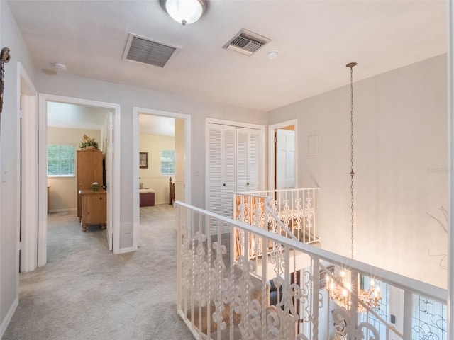 5556 Round Lake Rd, Apopka, FL 32712 - corridor with light colored carpet, an upstairs landing, and a chandelier