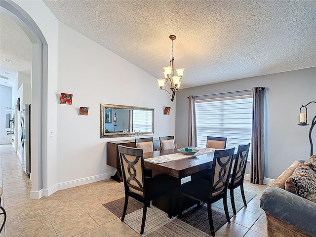 167 Castaway Beach Way, Kissimmee, FL 34746 - dining area featuring a textured ceiling, arched walkways, a chandelier, and light tile patterned flooring