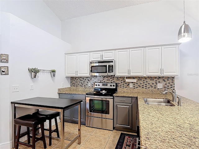167 Castaway Beach Way, Kissimmee, FL 34746 - kitchen with stainless steel appliances, decorative backsplash, white cabinets, light tile patterned floors, and a textured ceiling