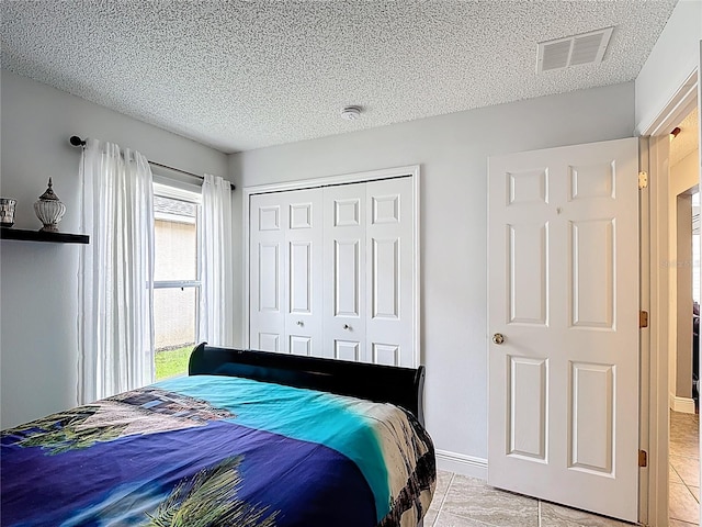 167 Castaway Beach Way, Kissimmee, FL 34746 - bedroom featuring a closet, a textured ceiling, and light tile patterned floors