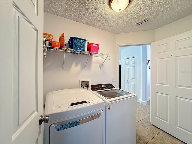 167 Castaway Beach Way, Kissimmee, FL 34746 - laundry room with washing machine and clothes dryer, a textured ceiling, and light tile patterned floors