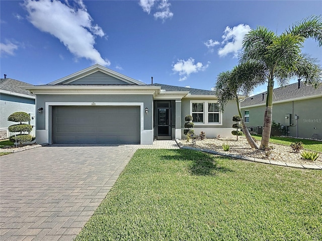 655 Conservation Blvd, Groveland, FL 34736 - ranch-style home featuring stucco siding, decorative driveway, an attached garage, and a front lawn