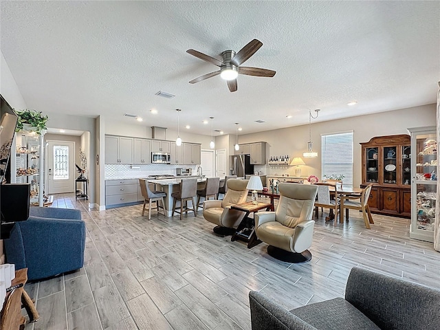 655 Conservation Blvd, Groveland, FL 34736 - living room featuring a ceiling fan, wood finish floors, a textured ceiling, and recessed lighting