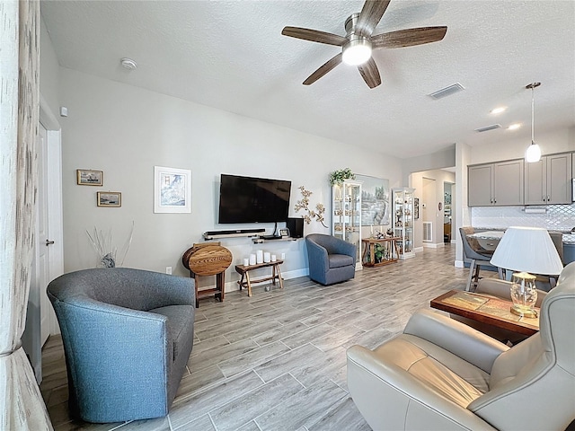655 Conservation Blvd, Groveland, FL 34736 - living room with ceiling fan, wood finish floors, and a textured ceiling