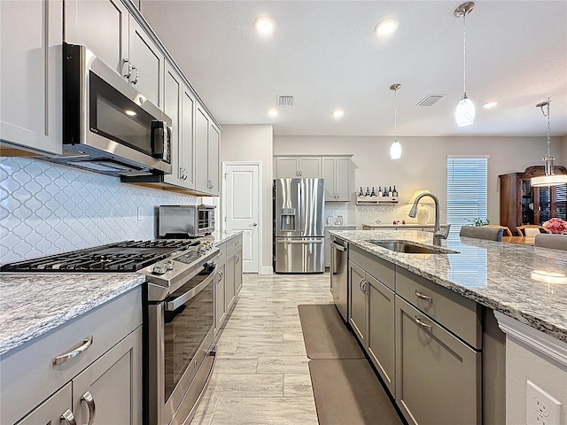 655 Conservation Blvd, Groveland, FL 34736 - kitchen featuring appliances with stainless steel finishes, gray cabinetry, backsplash, and recessed lighting