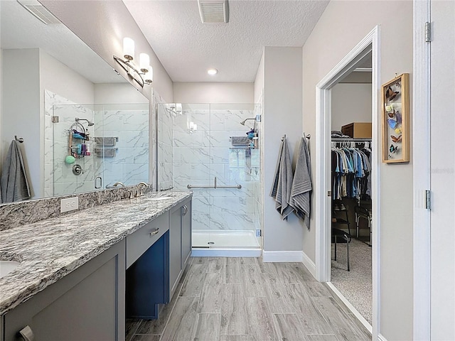 655 Conservation Blvd, Groveland, FL 34736 - full bath featuring vanity, a stall shower, a textured ceiling, a walk in closet, and wood finished floors