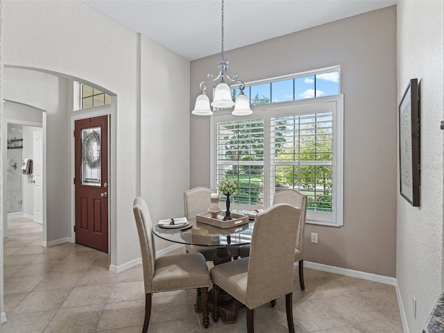 487 Thistledown Way, The Villages, FL 32162 - dining space with a chandelier, a textured wall, and arched walkways