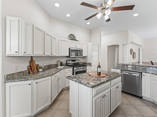 487 Thistledown Way, The Villages, FL 32162 - kitchen with stainless steel appliances, a center island, ceiling fan, white cabinets, and light tile patterned flooring