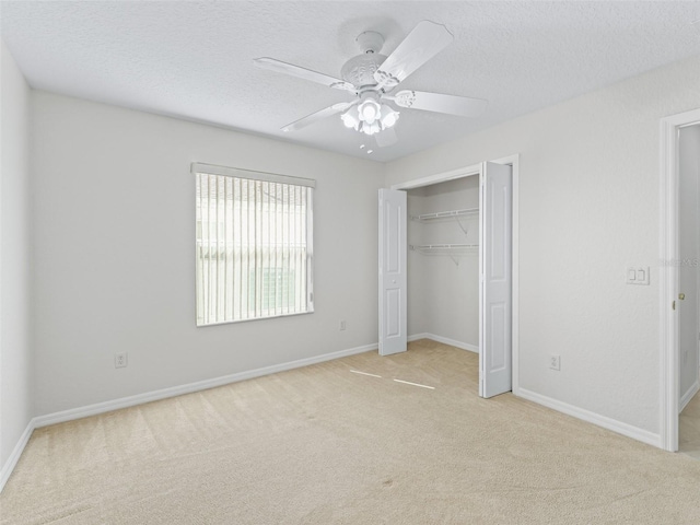 487 Thistledown Way, The Villages, FL 32162 - unfurnished bedroom with light colored carpet, a closet, a textured ceiling, and a ceiling fan