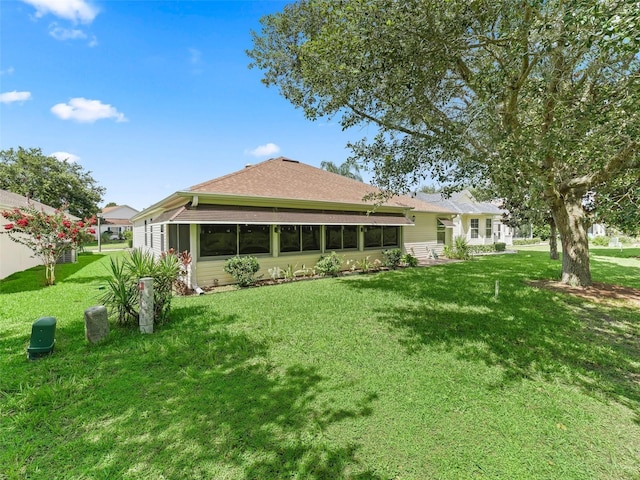 487 Thistledown Way, The Villages, FL 32162 - back of house with a lawn, a shingled roof, and a sunroom