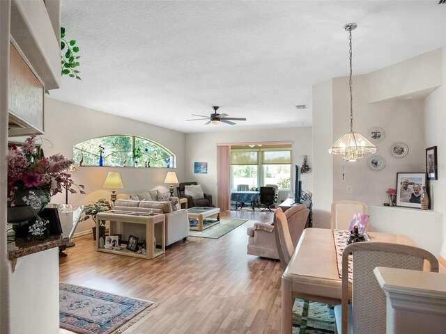 4814 Saint Andrews Arc, Leesburg, FL 34748 - living area with light wood-style flooring, ceiling fan, a chandelier, and a textured ceiling