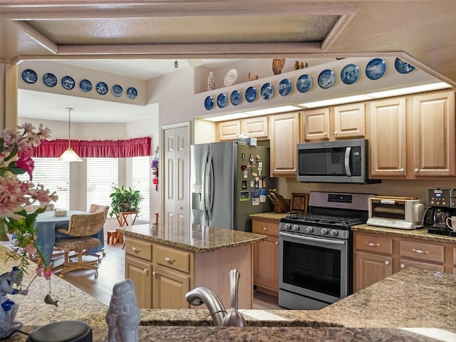 4814 Saint Andrews Arc, Leesburg, FL 34748 - kitchen featuring stainless steel appliances, light stone countertops, light wood finished floors, light brown cabinetry, and hanging light fixtures