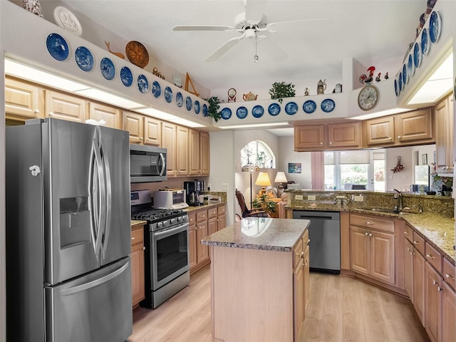 4814 Saint Andrews Arc, Leesburg, FL 34748 - kitchen featuring stainless steel appliances, light wood-style flooring, ceiling fan, a center island, and light brown cabinetry