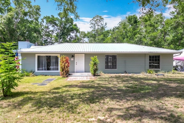 45 Forest Ln, Bronson, FL 32621 - ranch-style house with a chimney, a front lawn, and a metal roof