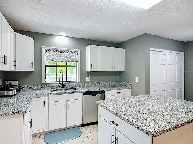 45 Forest Ln, Bronson, FL 32621 - kitchen featuring stainless steel dishwasher, a textured ceiling, light stone countertops, white cabinetry, and light tile patterned floors