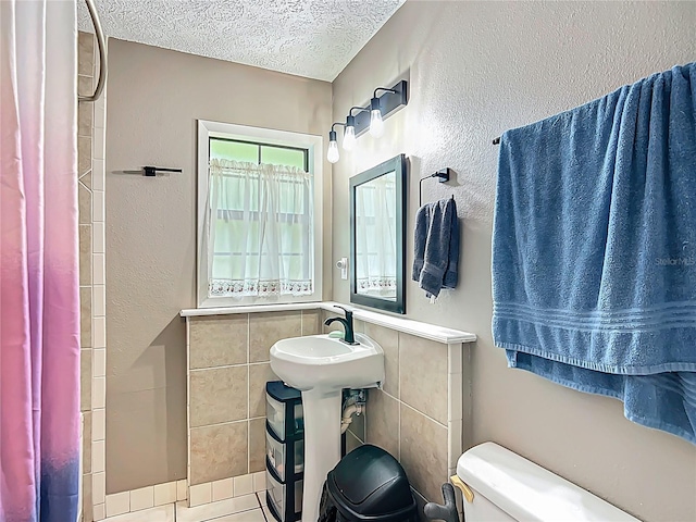 45 Forest Ln, Bronson, FL 32621 - full bathroom with a textured ceiling, a shower with shower curtain, tile walls, and tile patterned flooring