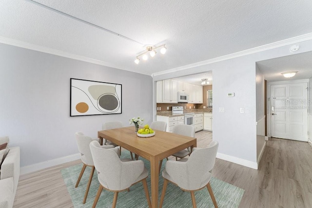 101 N Grandview St Unit 205, Mount Dora, FL 32757 - dining space featuring crown molding, light wood finished floors, and a textured ceiling