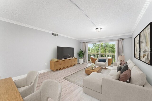 101 N Grandview St Unit 205, Mount Dora, FL 32757 - living room featuring wood finished floors, crown molding, and a textured ceiling