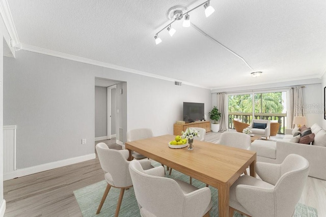 101 N Grandview St Unit 205, Mount Dora, FL 32757 - dining area with ornamental molding, a textured ceiling, and light wood-type flooring