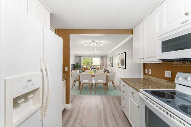 101 N Grandview St Unit 205, Mount Dora, FL 32757 - kitchen with white appliances, white cabinets, light wood-style floors, a textured ceiling, and rail lighting