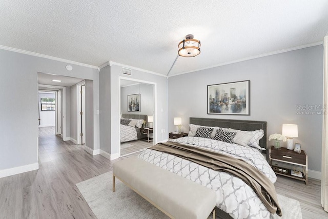 101 N Grandview St Unit 205, Mount Dora, FL 32757 - bedroom with light wood finished floors, crown molding, and a textured ceiling