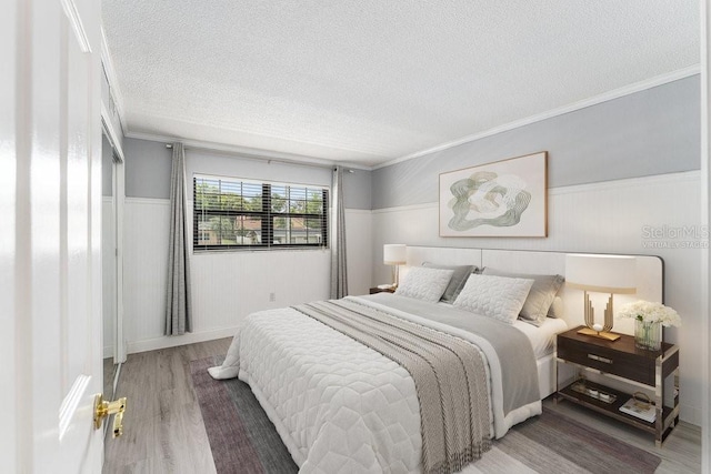 101 N Grandview St Unit 205, Mount Dora, FL 32757 - bedroom with a textured ceiling, wood finished floors, wainscoting, and ornamental molding