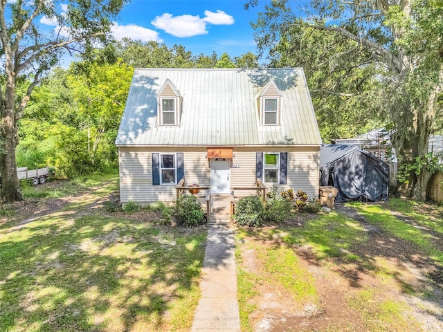 323 Savage Way, Groveland, FL 34736 - cape cod-style house featuring a metal roof and a front yard