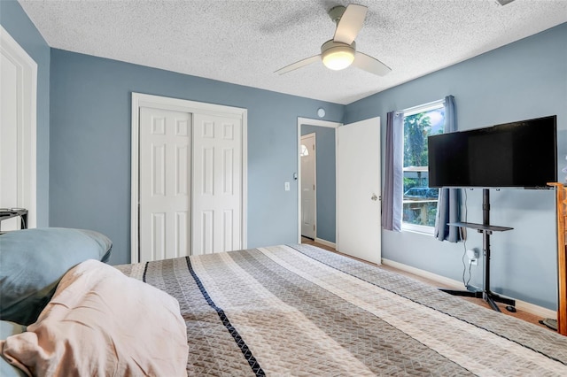 323 Savage Way, Groveland, FL 34736 - bedroom featuring a closet, a textured ceiling, a ceiling fan, and wood finished floors