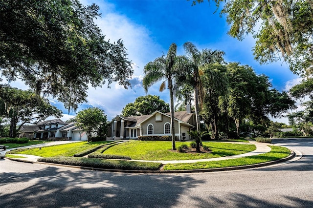 681 Greywood Dr, Altamonte Springs, FL 32701 - view of property hidden behind natural elements with concrete driveway, a garage, a front yard, and a chimney