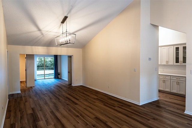 681 Greywood Dr, Altamonte Springs, FL 32701 - unfurnished living room featuring vaulted ceiling, dark wood finished floors, and a chandelier