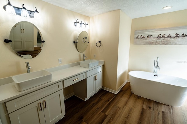 681 Greywood Dr, Altamonte Springs, FL 32701 - full bath featuring double vanity, wood finished floors, a soaking tub, and a textured ceiling
