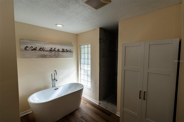 681 Greywood Dr, Altamonte Springs, FL 32701 - full bathroom featuring wood finished floors, a textured ceiling, a soaking tub, and a shower stall