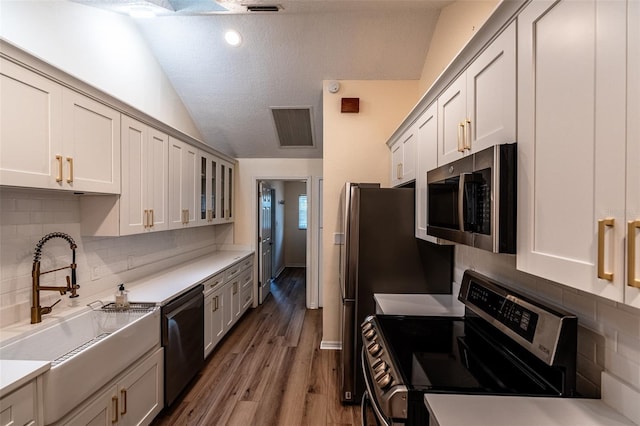 681 Greywood Dr, Altamonte Springs, FL 32701 - kitchen with appliances with stainless steel finishes, lofted ceiling, decorative backsplash, glass insert cabinets, and light countertops