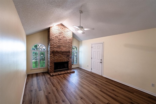 681 Greywood Dr, Altamonte Springs, FL 32701 - unfurnished living room with ceiling fan, wood finished floors, a textured ceiling, lofted ceiling, and a brick fireplace