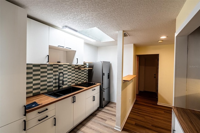 681 Greywood Dr, Altamonte Springs, FL 32701 - kitchen featuring butcher block countertops, freestanding refrigerator, light wood-style flooring, white cabinetry, and a textured ceiling